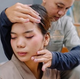 Terapis Laraneya memijat kepala klien